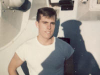 Ordinary Seaman Fire Control Hutton in from of Gun on HMCS Assisiniboine